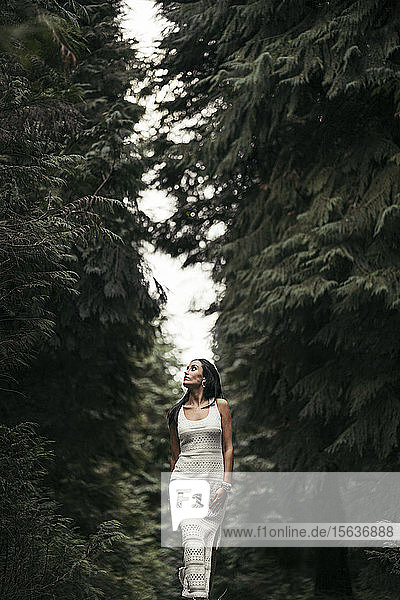 Junge Frau in weißem Kleid im Wald