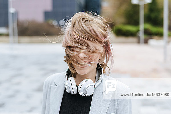 Glückliche Frau mit Kopfhörern  die ihr Haar bewegen