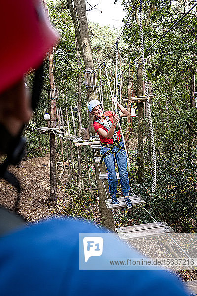 Woman on a high rope course in forest