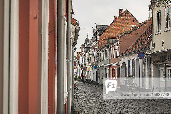 Dänemark  Aeroe  Aeroskobing  Farbenfrohe traditionelle Stadthäuser auf leerer Straße gesehen