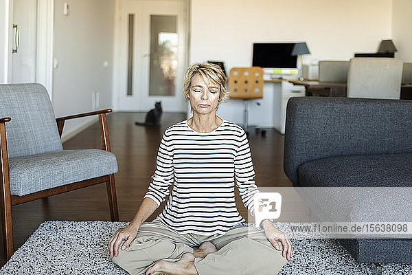 Reife Frau  die zu Hause Yoga praktiziert