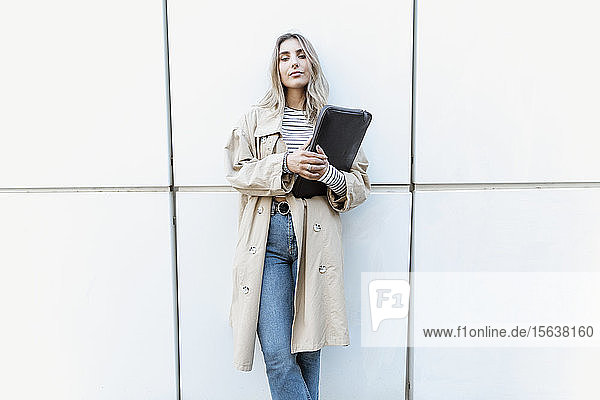 Junge blonde Frau hält Laptoptasche