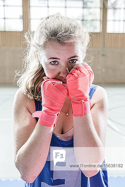 Portrait of confident female boxer in sports hall