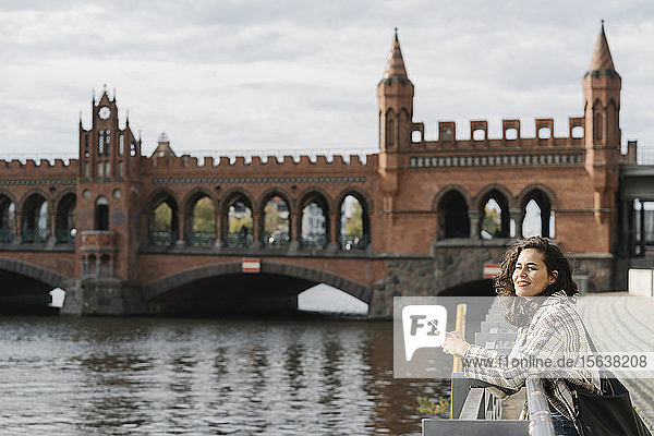 Frau mit Smartphone in der Stadt an der Oberbaumbrücke  Berlin  Deutschland