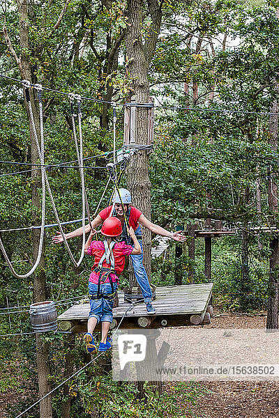 Mother and daughter on a high rope course in forest