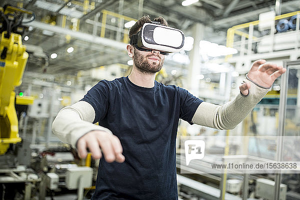 Mann mit VR-Brille in moderner Fabrik