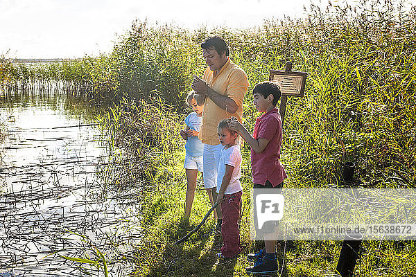Father and children standing at water course  Darss  Mecklenburg-Western Pomerania  Germany