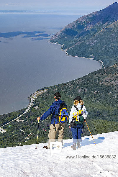Hikers in the Chugach Mountains South of Anchorage  South-central Alaska. Summer. Couple is overlooking Turnagain Arm and the Seward Highway; Alaska  United States of America