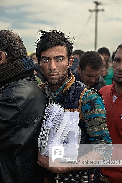Refugee with a pile of papers in line for a visa  refugee camp Idomeni at the Greek-Macedonian border  Idomeni  Greece  Europe
