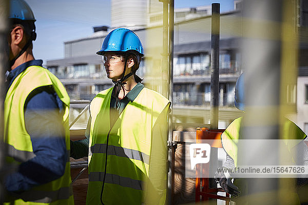 Male and female architects in protective workwear at construction site