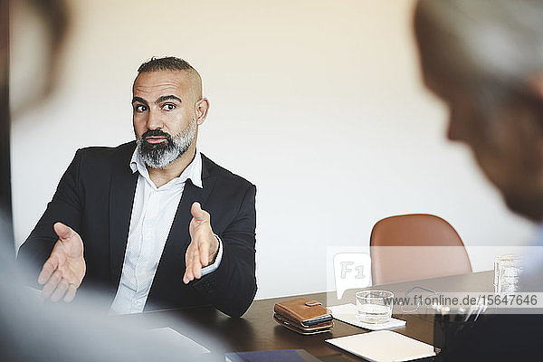 Mature financial advisor discussing at conference table in meeting