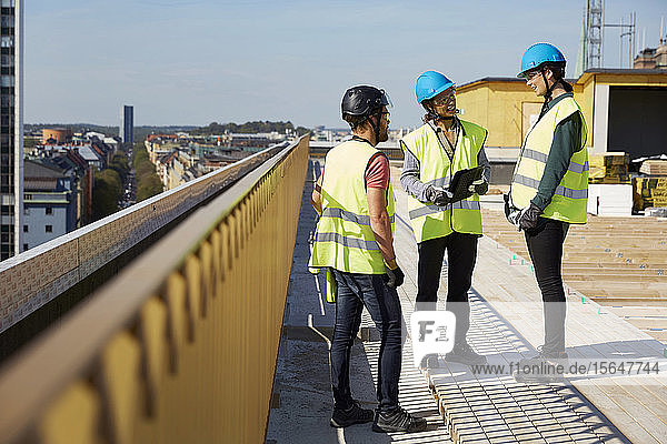 Male and female architects discussing at construction site