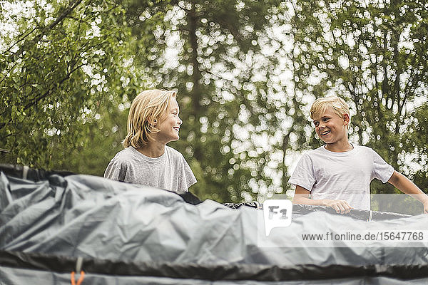Aufgeregtes Geschwisterpaar beim gemeinsamen Zeltaufbau auf dem Campingplatz