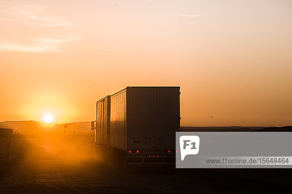 Silhouetten-Lkw bei Sonnenuntergang auf der Straße
