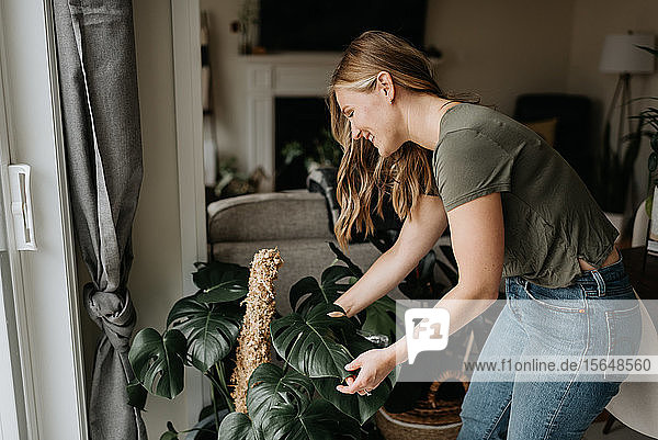 Frau kümmert sich um Zimmerpflanzen
