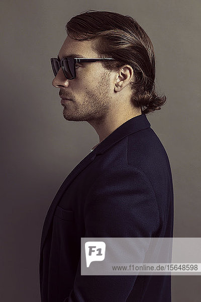 Man in jacket looking cool with sunglasses  grey background