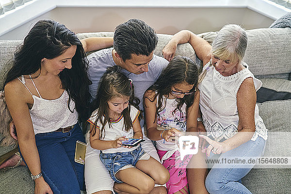 Three generation family enjoying computer games on sofa