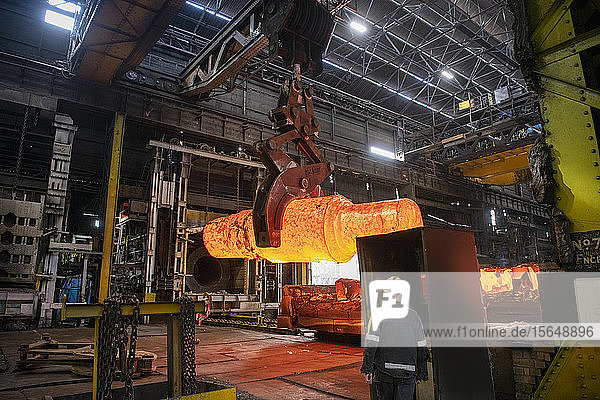 Red hot steel ingot being craned to forge in steelworks