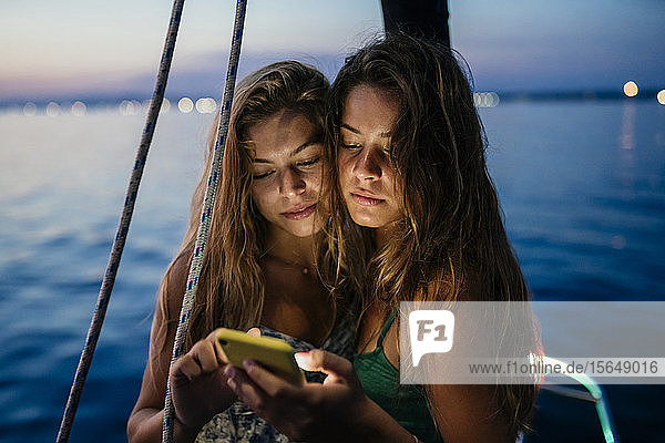 Freunde auf einem Segelboot  Textnachrichten austauschen  Italien