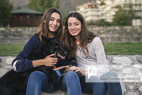 Sisters with dog in park