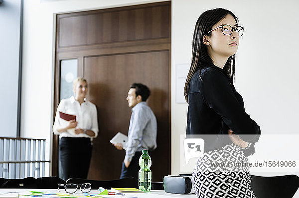 Young businesswoman in office  colleagues talking in background