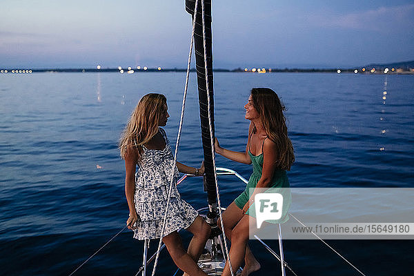 Freunde entspannen abends auf einem Segelboot  Italien