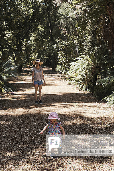 Mother and baby girl taking walk through forest
