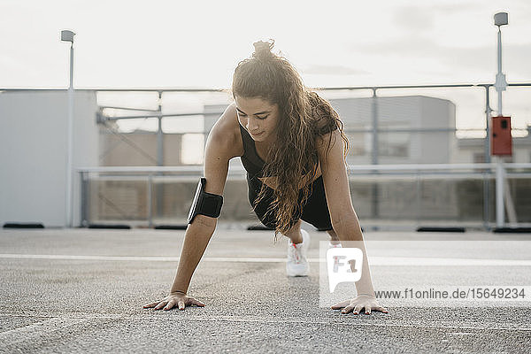 Young woman doing plank on rooftop deck