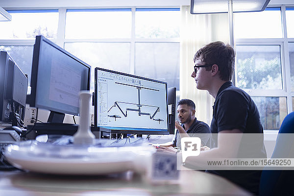 Worker looking at CAD design of product in electronics assembly factory