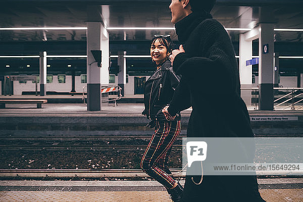 Young couple running on platform in train station  Milan  Italy