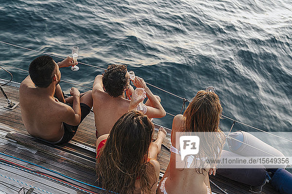Freunde genießen Champagner auf einem Segelboot  Italien