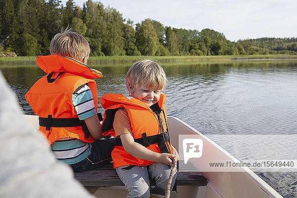 Adult sailing with boys on boat in lake  Finland