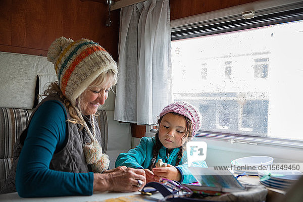 Grandmother and granddaughter playing in a campervan