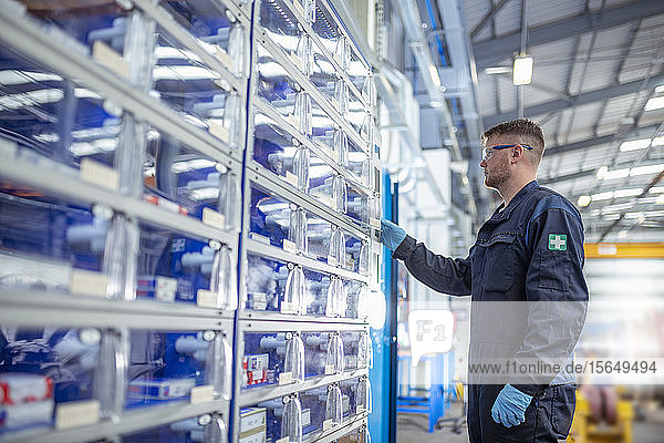 Engineer operating tool and parts vending machine in electrical engineering factory