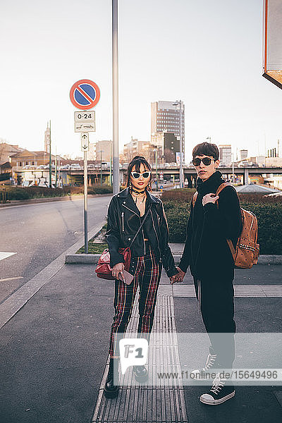 Junges Paar hält Händchen und wartet auf der Straße  Mailand  Italien