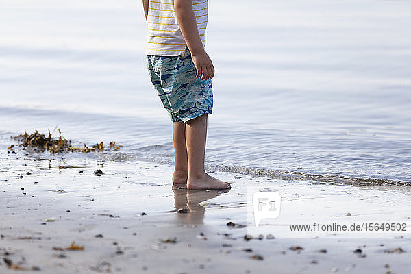 Junge am Strand stehend