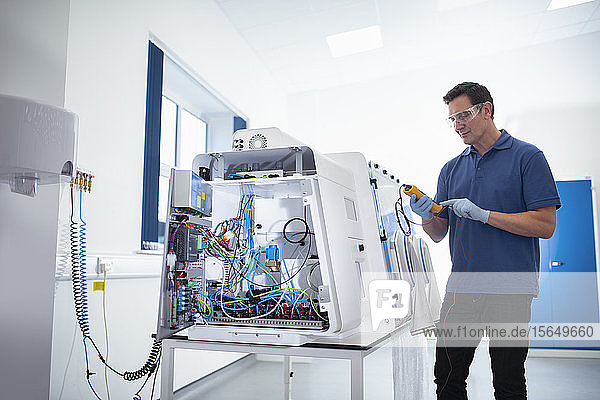 Worker testing laboratory cabinet on production line in medical science factory