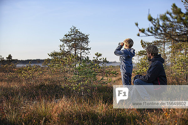 Vater und Sohn erkunden Wald  Finnland