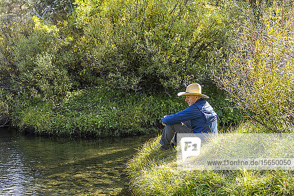 Mann sitzt im Gras bei Dampf in Stanley  Idaho  USA