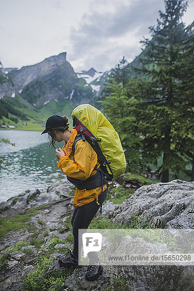 Woman wearing yellow hiking by Seealpsee lake in Appenzell Alps  Switzerland