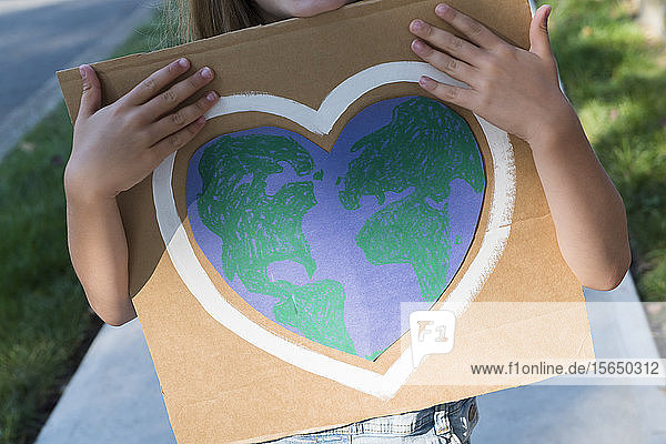 Young environmental activist holding sign