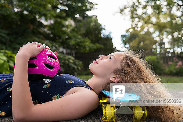 Mädchen liegend auf Skateboard
