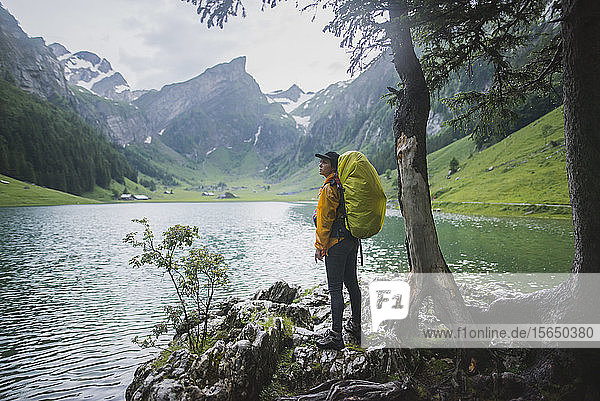 Frau mit gelbem Rucksack am Seealpsee in den Appenzeller Alpen  Schweiz