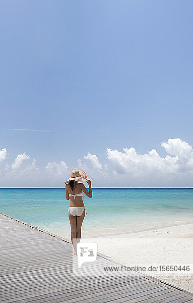 Woman wearing bikini by beach in South Male Atoll  Maldives  South Asia