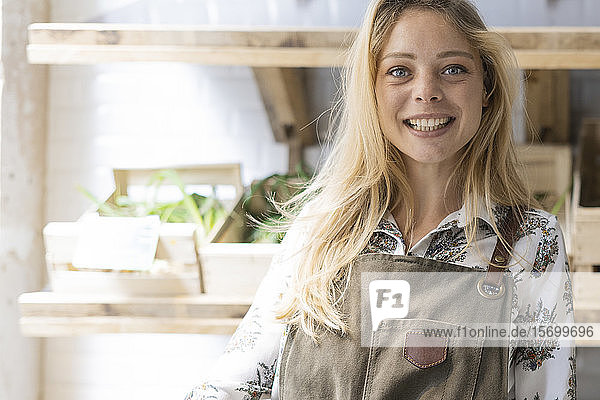 Lächelnde junge Frau mit Weidenkorb im Lebensmittelgeschäft