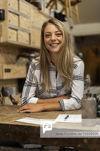Lächelnde Frau in der Werkstatt stehend