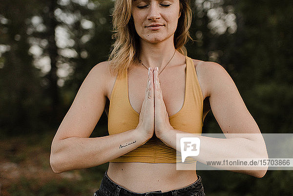 Frau praktiziert Yoga im Wald