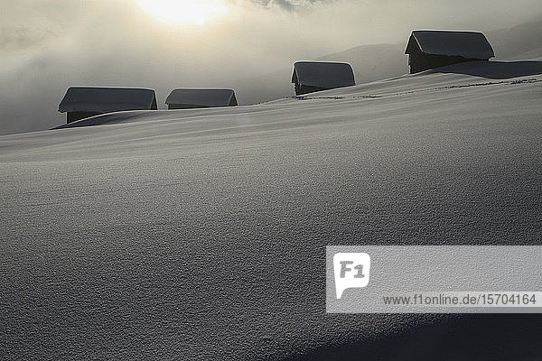 Verschneite Hütten am sonnigen  ruhigen Berghang  Vella  Kanton Graubünden  Schweiz