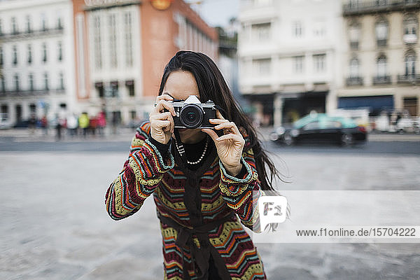 Porträt einer weiblichen Touristin mit Kamera auf einer Straße in der Stadt