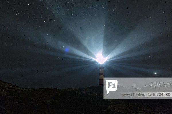 Vom Leuchtturm aus leuchtende Leuchtfeuer unter dem nächtlichen Sternenhimmel  Wittduen  Deutschland
